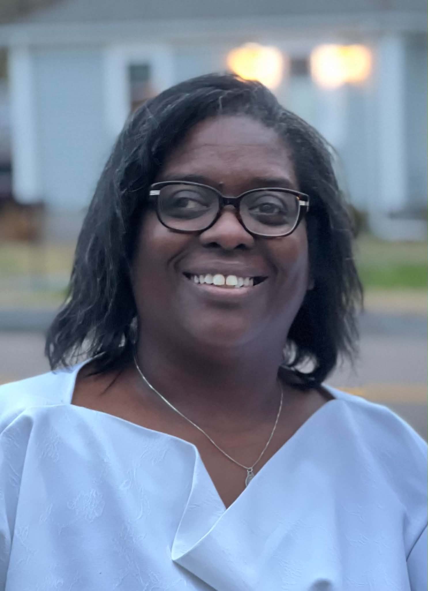 Maggie Jean-Baptiste smiling in a light blue blouse